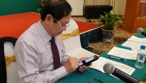 Bộ trưởng Nội vụ Lê Vĩnh Tân miệt mài trả lời tin nhắn của địa phương về việc tạm dừng sáp nhập sở trong giờ giải lao hội nghị.