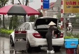 Hành động lạ bên cạnh chiếc ô tô của người phụ nữ bán nước dưới cơn mưa nặng hạt khiến dân mạng đứng hình