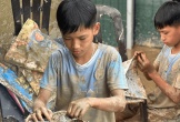 Cậu bé 12 tuổi lật từng trang sách lấm bùn sau lũ quét ở Nghệ An: “Chữ vẫn còn đọc được cô ạ!”