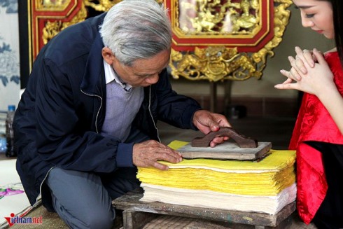 Nghệ nhân Nguyễn Đăng Chế hướng dẫn khách tham quan cách làm ra một bức tranh Đông Hồ