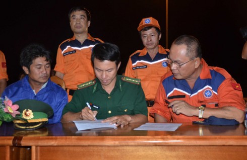 Thuyền trưởng Phan Xuân Sơn trên tàu SAR 412 Thuyền trưởng Sơn (ngoài cùng bên phải) trong lần bàn giao ngư dân gặp nạn cho bộ đội biên phòng.