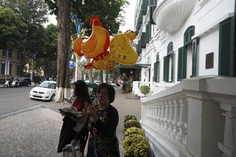 Một gia đình đi du xuân mang bóng bay hình con gà